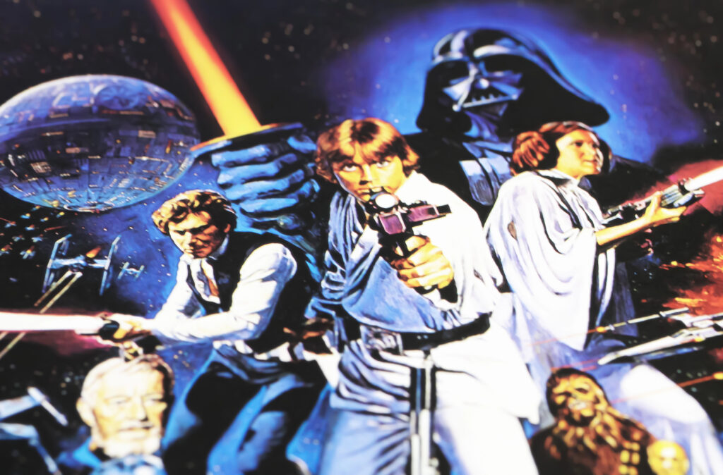 Photo focused on the center of the 1977 Star Wars movie poster showing Luke Skywalker with a ray gun in the center Leia to Luke's right and Han to his left holding a light saber, behind them, looming over them is Darth Vader holding a light saber, in the right corner is a head shot of Chewie and in the left corner a head shot of Obi Wan Kenobi. This photo precedes a section devoted to showing the story structure and plot point in this well-known film