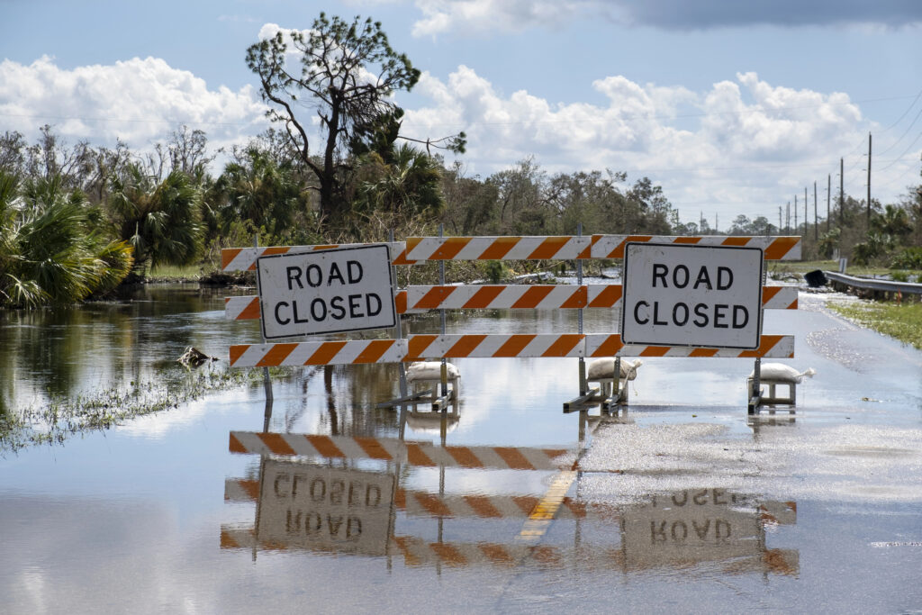 Photograph of a road closed barrier across a road that is flooded represents what happens when story structure isn't used or is used ineffectively